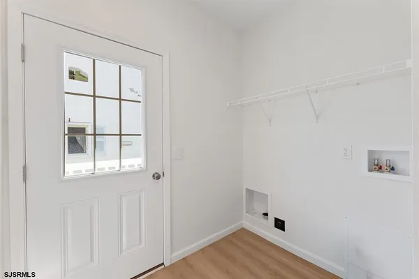 an empty room with a window and wooden floor