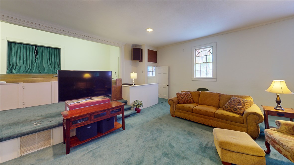 415 Church Street Pendleton, SC 29670 - Photo 9 of 35 A split-level room showcases a cozy atmosphere with soft carpeting and functional architectural details.