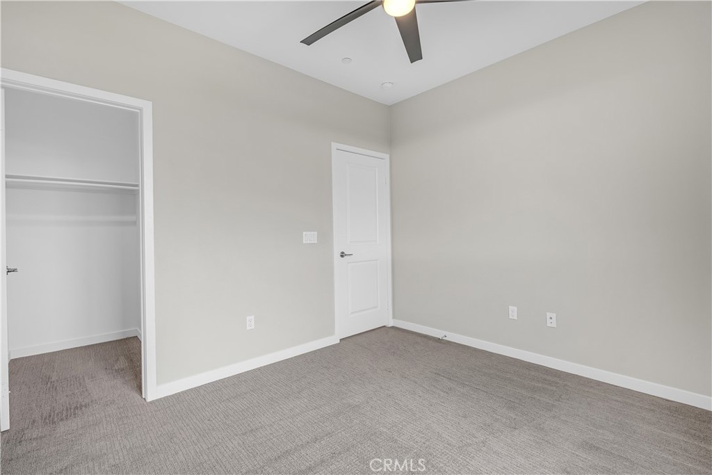 755 Sawyer Place Upland, CA 91786 - Photo 41 of 57 an empty room with a ceiling fan and carpet