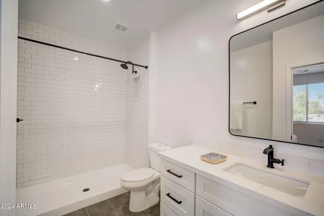 a bathroom with a sink mirror toilet and shower