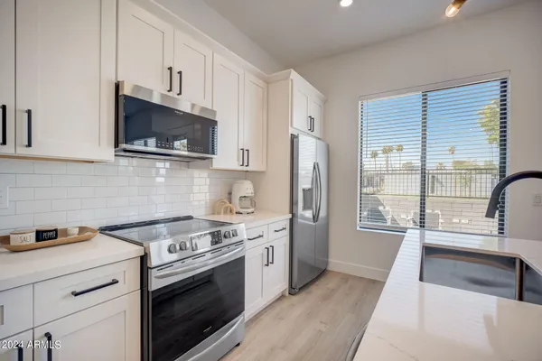a kitchen with stainless steel appliances a stove a sink and a microwave