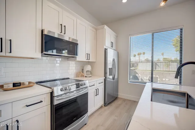 a kitchen with stainless steel appliances a stove a sink and a microwave