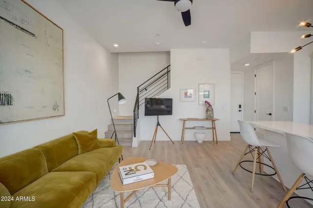 a living room with furniture and a wooden floor