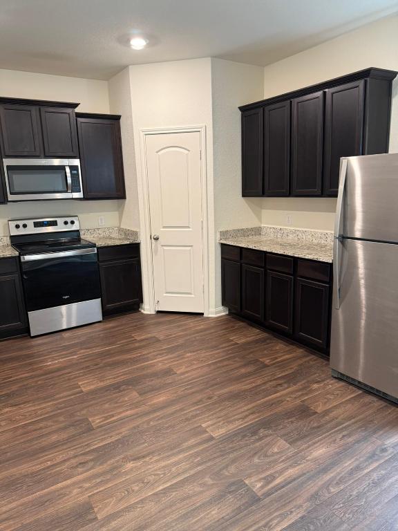 14325 Boomtown Way Elgin, TX 78621 - Photo 2 of 29 a kitchen with granite countertop a refrigerator and a stove top oven