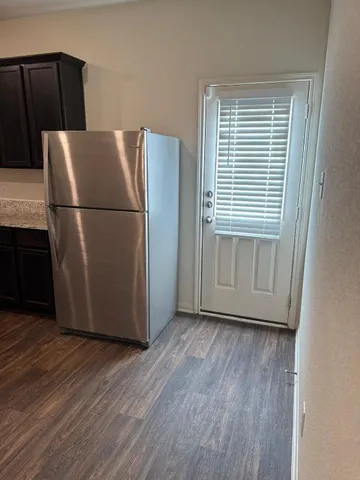 a view of a kitchen with wooden floor and a refrigerator