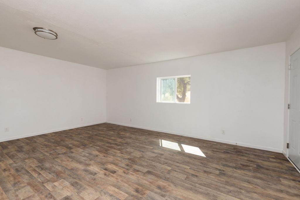 28369 Road 400 Madera, CA 93636 - Photo 23 of 33 a view of empty room with wooden floor and fan