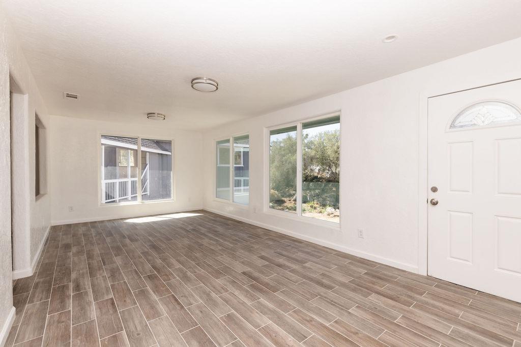 28369 Road 400 Madera, CA 93636 - Photo 3 of 33 a view of an empty room with wooden floor and a window