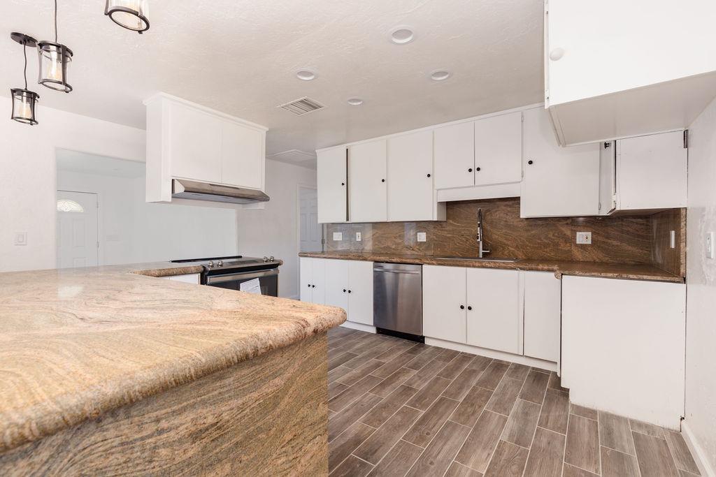 28369 Road 400 Madera, CA 93636 - Photo 7 of 33 a kitchen with granite countertop white cabinets and white appliances
