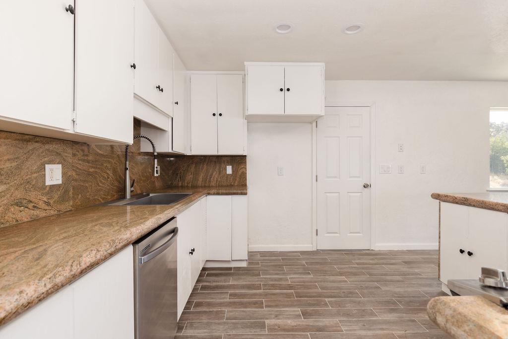 28369 Road 400 Madera, CA 93636 - Photo 8 of 33 a kitchen with granite countertop white cabinets and stainless steel appliances