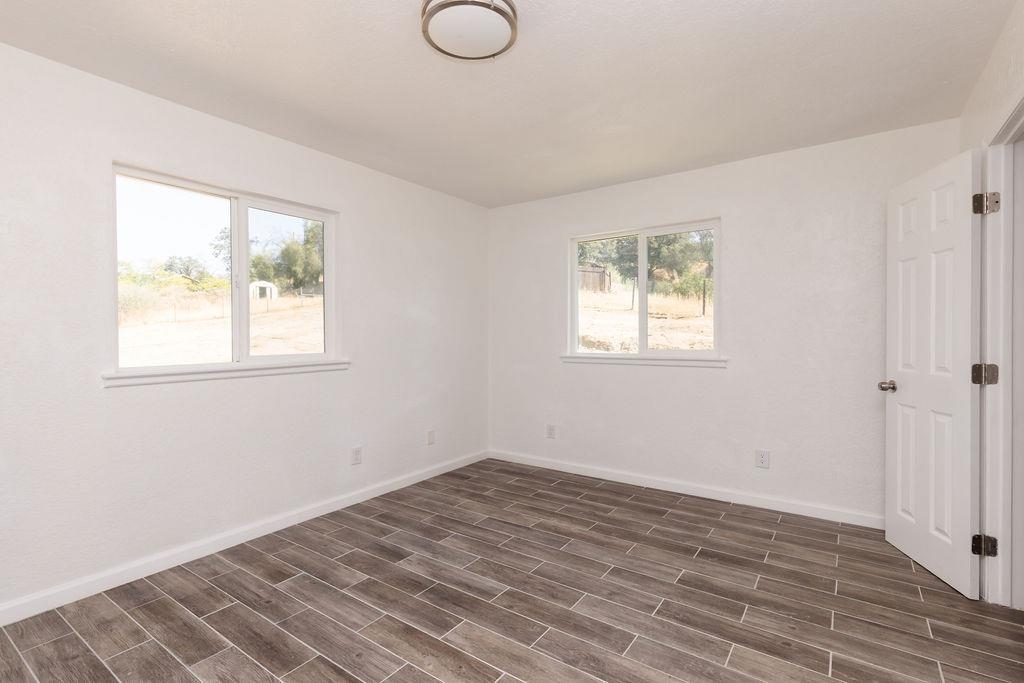 28369 Road 400 Madera, CA 93636 - Photo 9 of 33 a view of empty room with wooden floor and fan