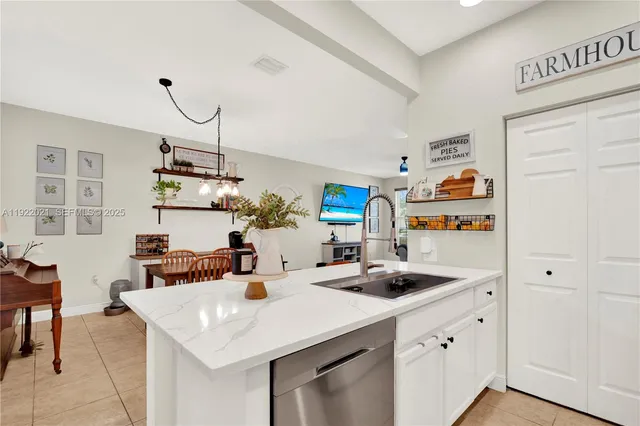 a kitchen with a white cabinets and chandelier