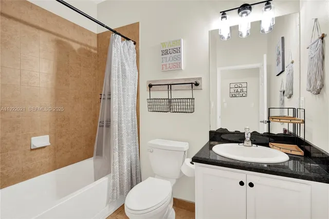 a bathroom with a sink a toilet a mirror a vanity and shower