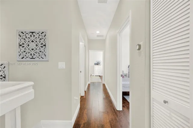 a view of a hallway with wooden floor and staircase
