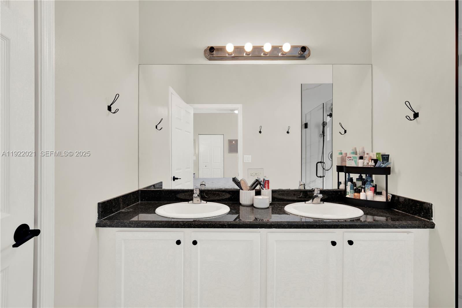 1121 Southwest 147th Terrace Pembroke Pines, FL 33027 - Photo 22 of 32 a sink with a mirror and vanity