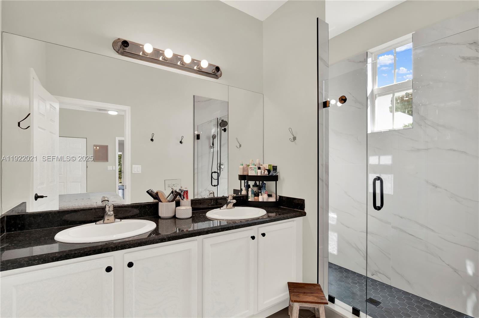 1121 Southwest 147th Terrace Pembroke Pines, FL 33027 - Photo 23 of 32 a bathroom with a double vanity sink and mirror