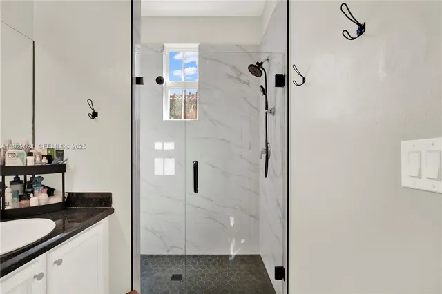 a bathroom with a granite countertop shower mirror and a sink