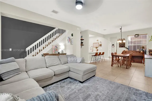 a living room with furniture and a dining table with projector