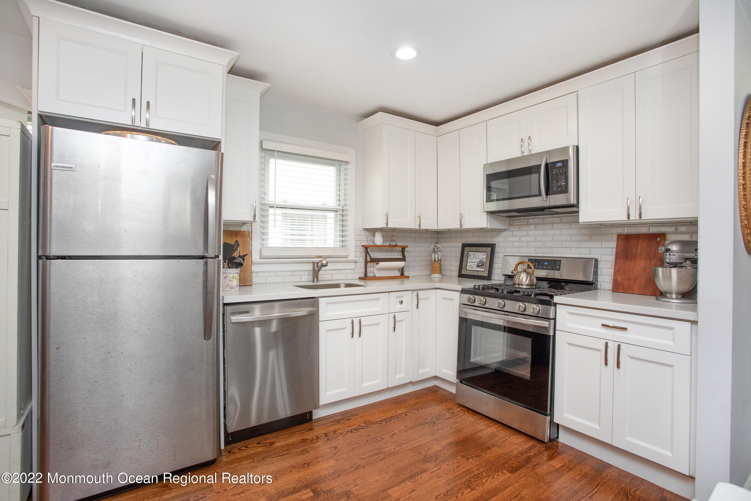 111 Manito Road Manasquan, NJ 08736 - Photo 15 of 37 a kitchen with white cabinets stainless steel appliances and a window