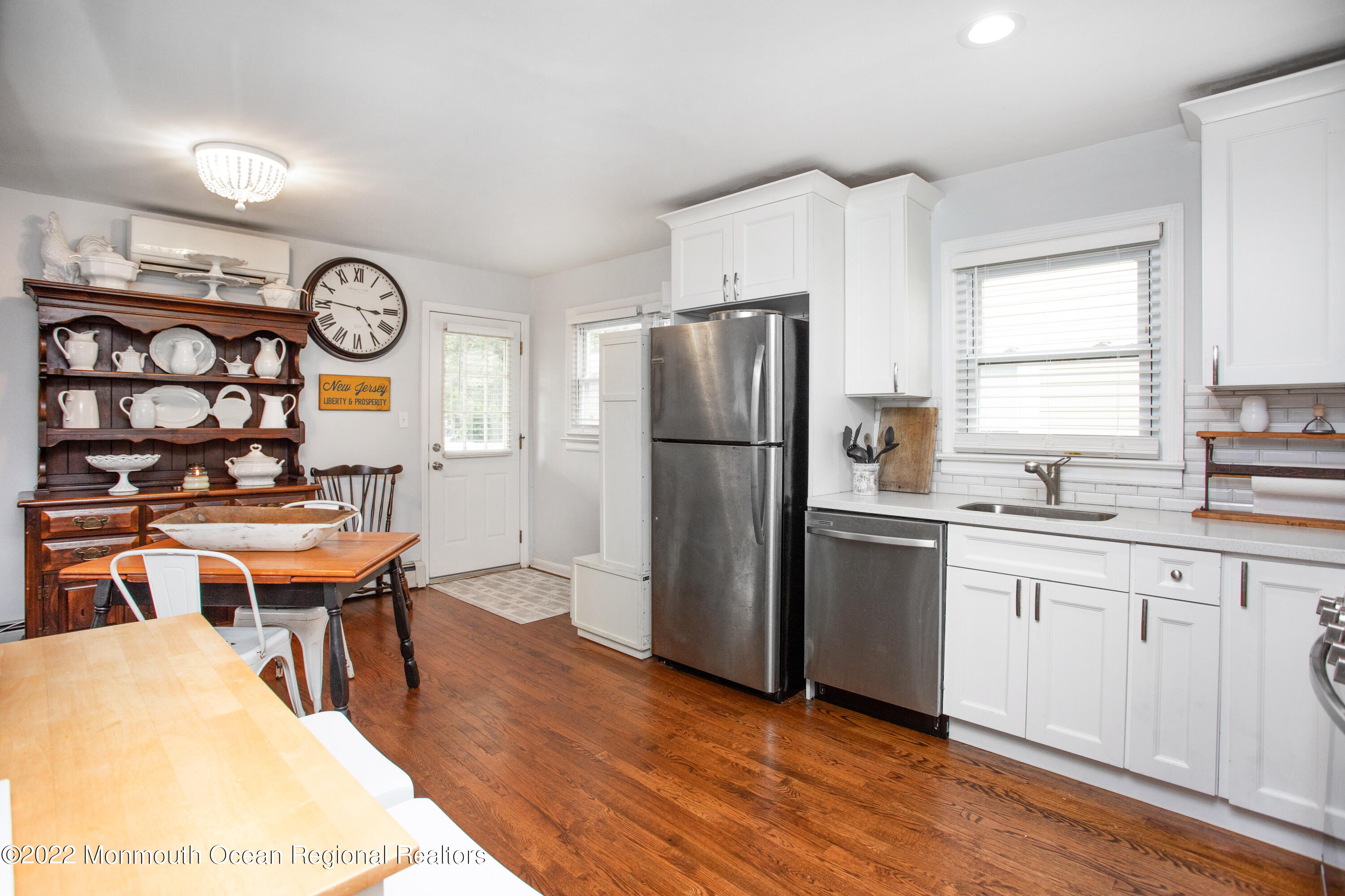 111 Manito Road Manasquan, NJ 08736 - Photo 16 of 37 a kitchen with stainless steel appliances granite countertop a refrigerator a sink dishwasher a stove and a dining table with wooden floor