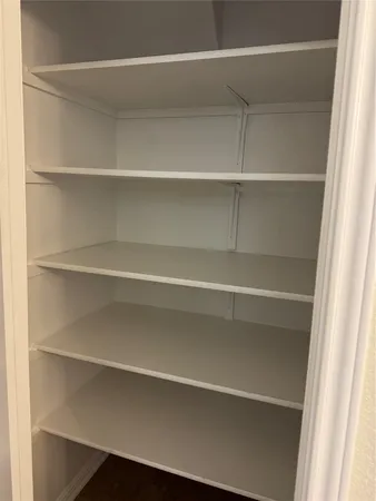 a view of walk in closet with empty racks