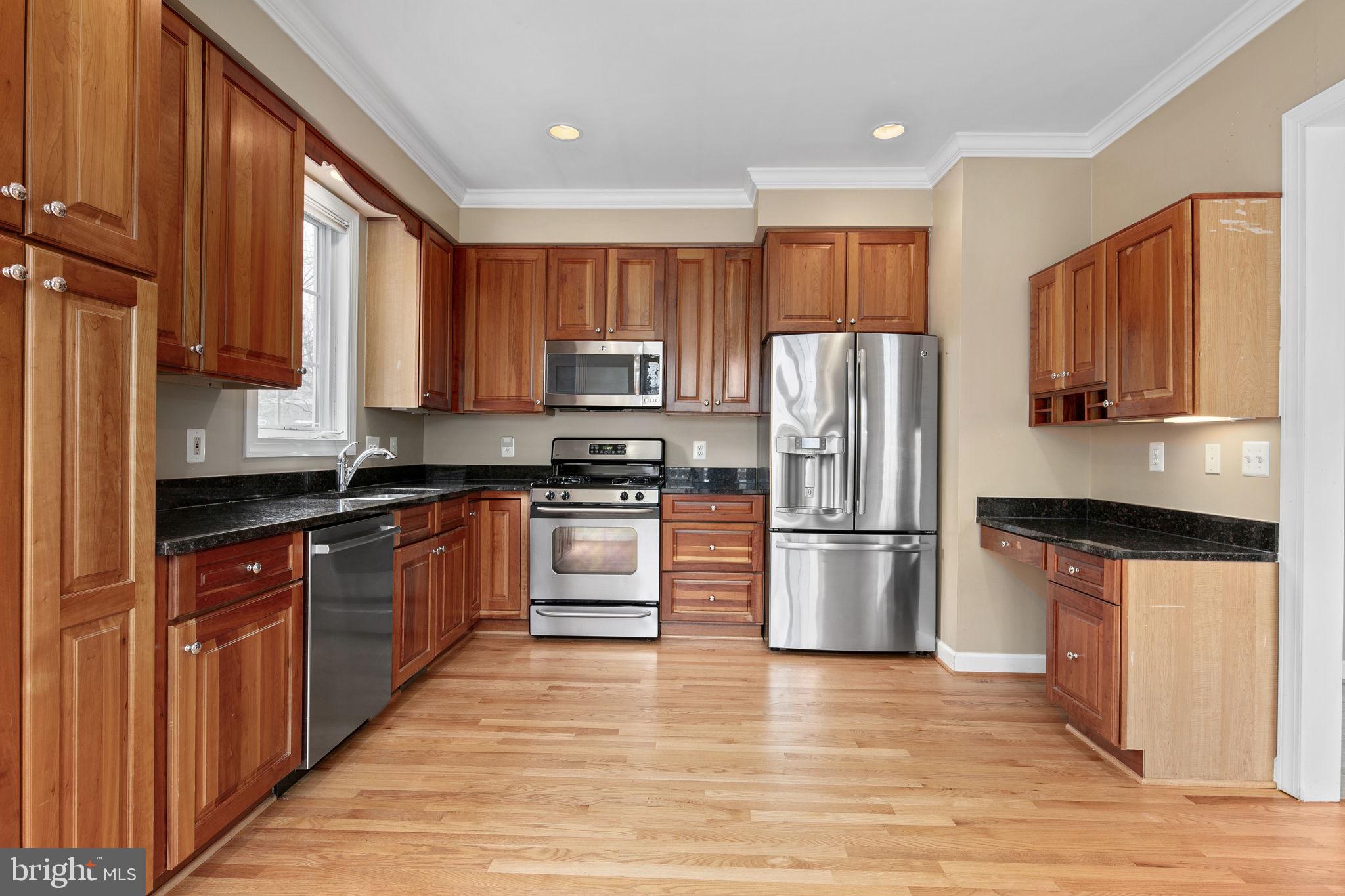 a kitchen with stainless steel appliances granite countertop a refrigerator microwave and sink