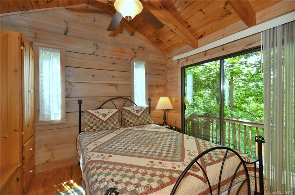381 Norman Road Clyde, NC 28721 - Photo 20 of 21 a bedroom with a bed and large windows