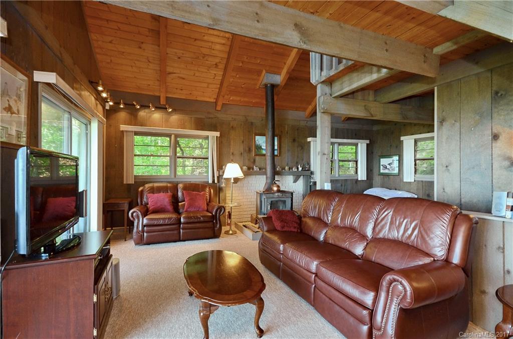 381 Norman Road Clyde, NC 28721 - Photo 3 of 21 a living room with furniture a flat screen tv and a large window