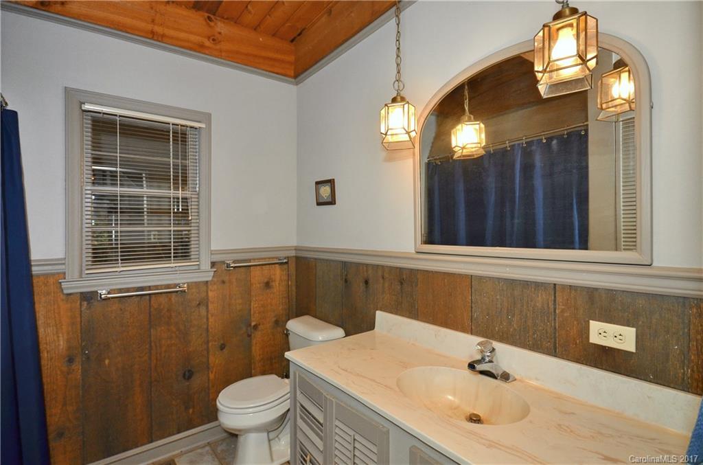 381 Norman Road Clyde, NC 28721 - Photo 8 of 21 a bathroom with a sink a toilet and mirror