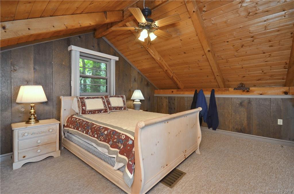 381 Norman Road Clyde, NC 28721 - Photo 9 of 21 a bedroom with a bed and a ceiling fan