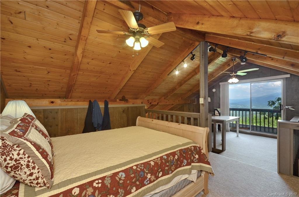 381 Norman Road Clyde, NC 28721 - Photo 10 of 21 a bed room with a bed and a chandelier