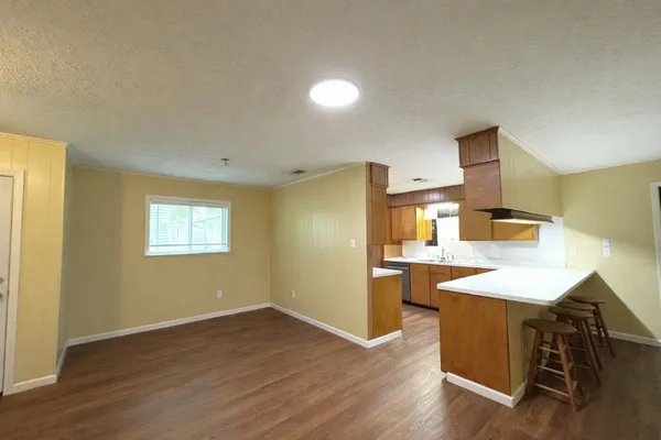 a kitchen with granite countertop stainless steel appliances a sink stove and cabinets