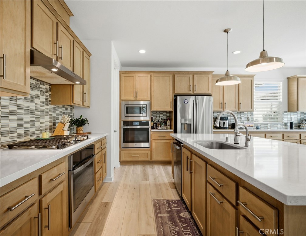 32243 Penstemon Way Temecula, CA 92591 - Photo 3 of 26 a kitchen with stainless steel appliances granite countertop a sink stove and refrigerator