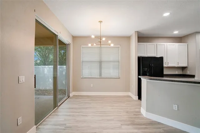 a large kitchen with stainless steel appliances granite countertop a large counter top a sink and a refrigerator