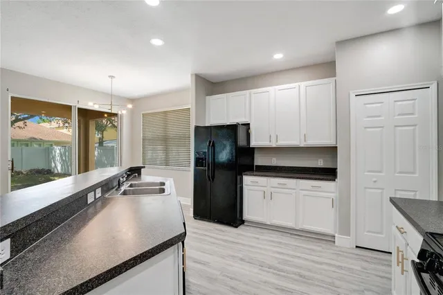 a kitchen with granite countertop a sink stove and cabinets