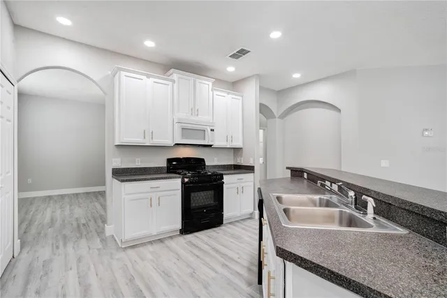 a kitchen with granite countertop a sink and cabinets