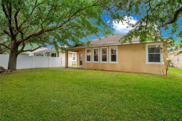 a view of a white house with a big yard and potted plants