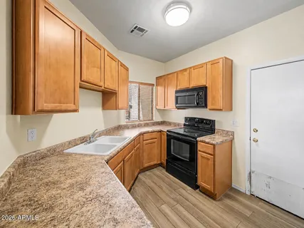 a kitchen with granite countertop a sink and a stove top oven