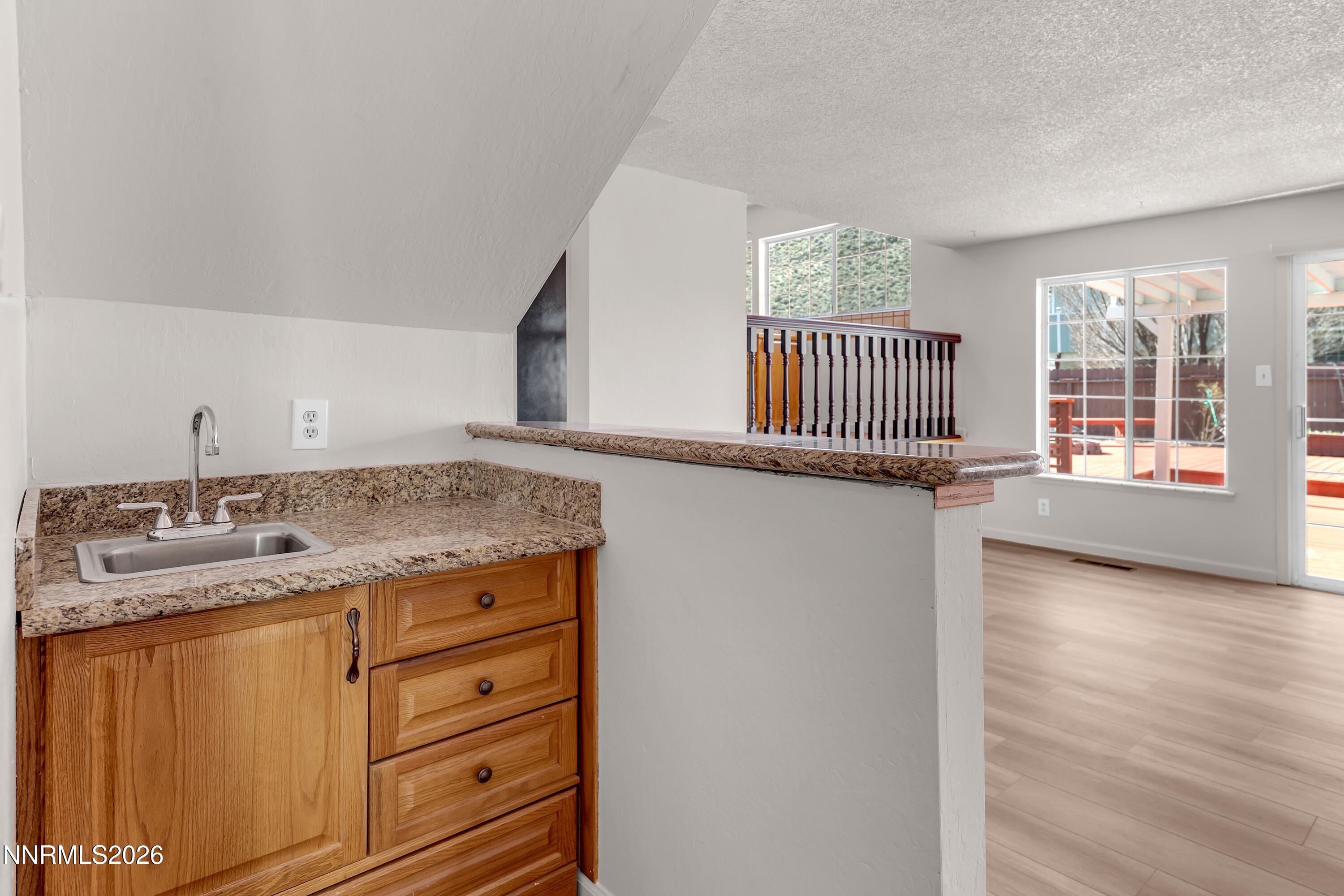 4505 Gorc Way Reno, NV 89502 - Photo 22 of 48 a hall with kitchen island granite countertop white cabinets and a wooden floor