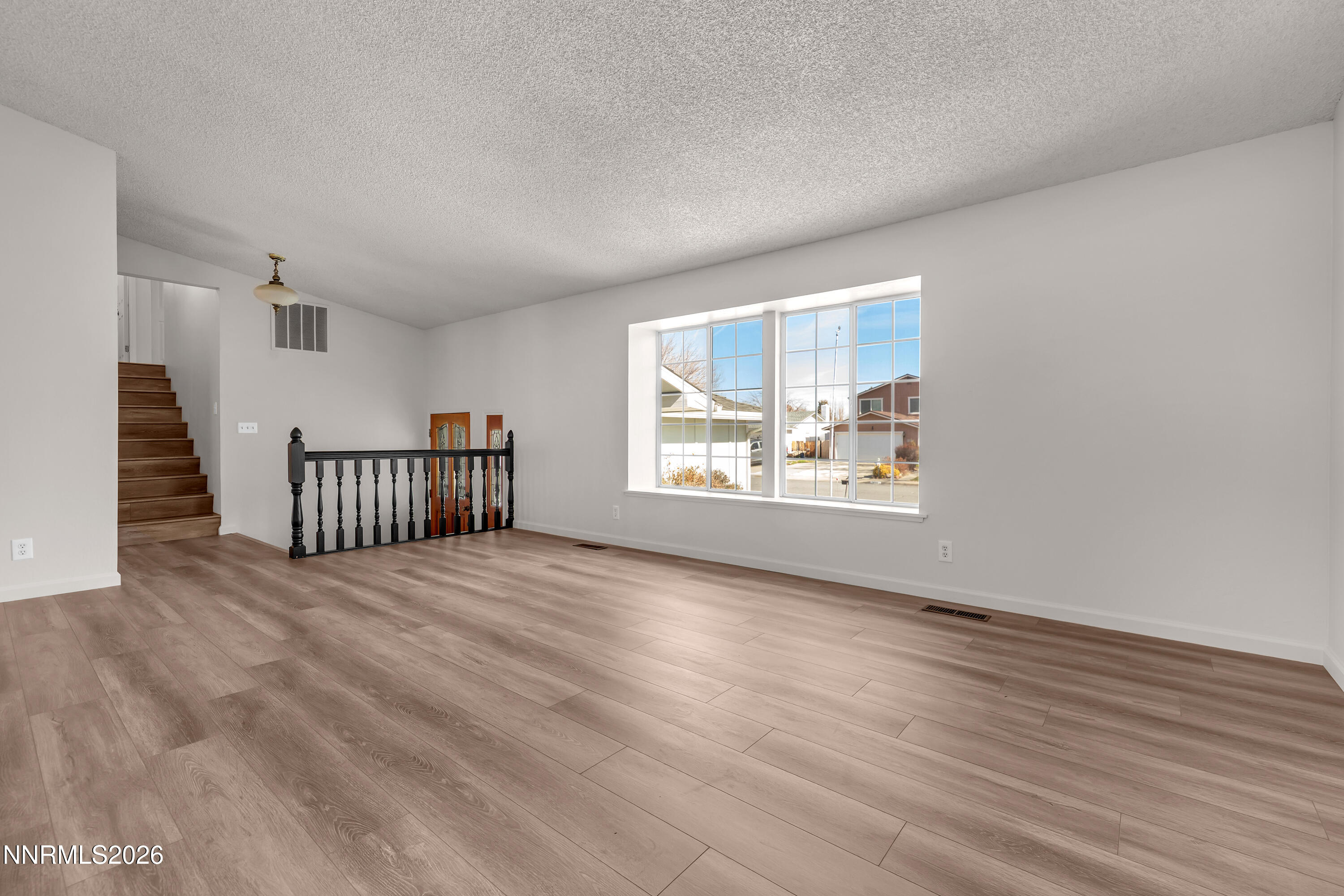 4505 Gorc Way Reno, NV 89502 - Photo 4 of 48 a view of an empty room with wooden floor and a window