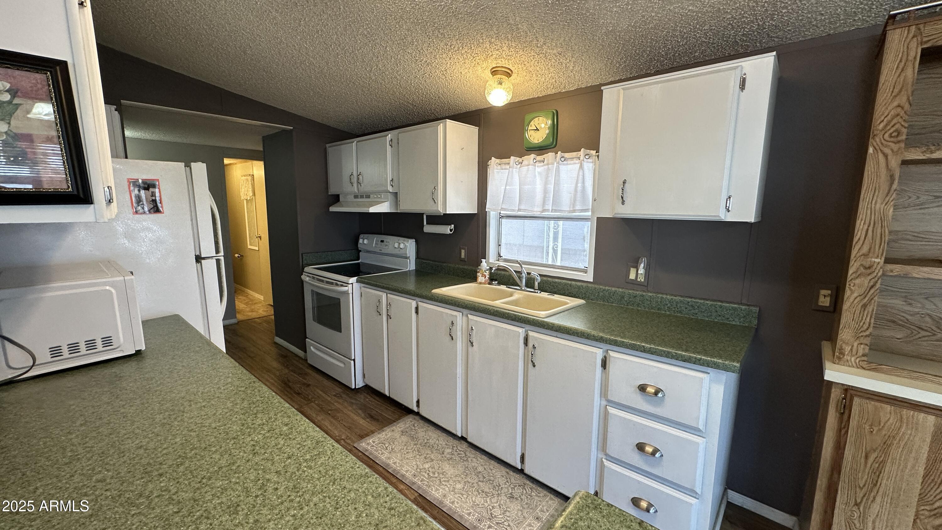 834 South Meridian Road, Unit 105 Apache Junction, AZ 85120 - Photo 10 of 48 a kitchen with granite countertop a sink a stove and cabinets