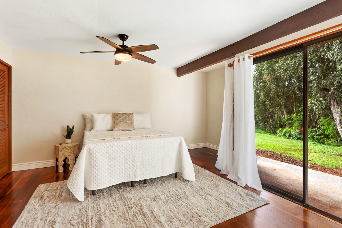 4701 Kawaihau Road, Unit L102 Kapaa, HI 96746 - Photo 11 of 22 a bedroom with a bed and glass door