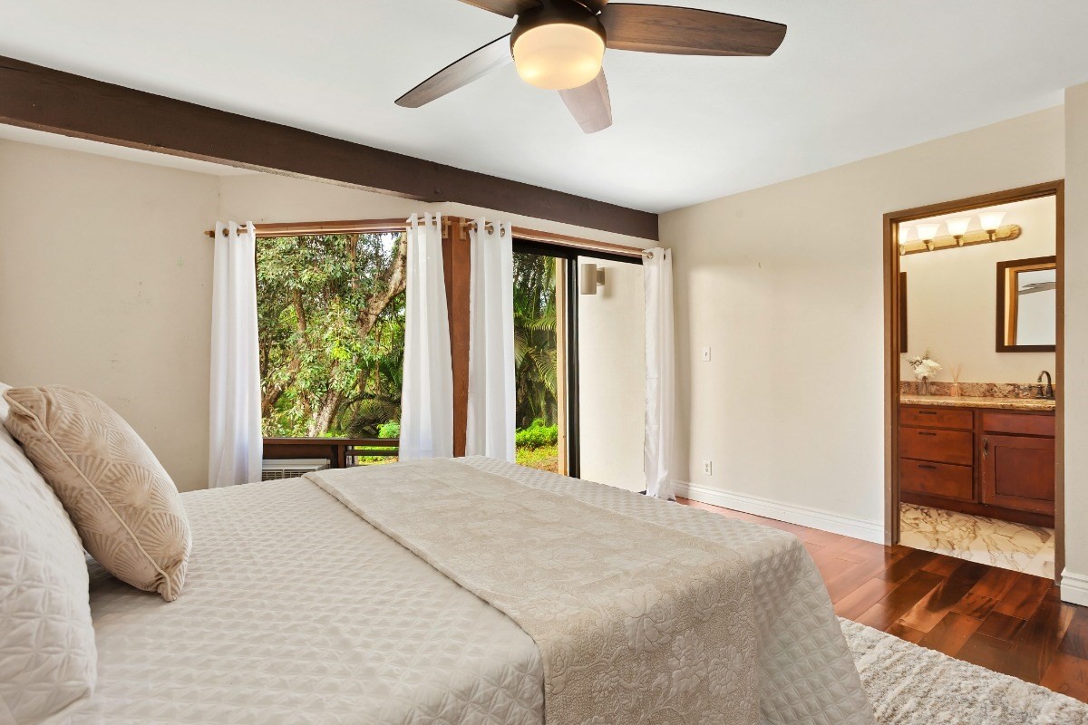 4701 Kawaihau Road, Unit L102 Kapaa, HI 96746 - Photo 12 of 22 a bedroom with a bed and a chandelier