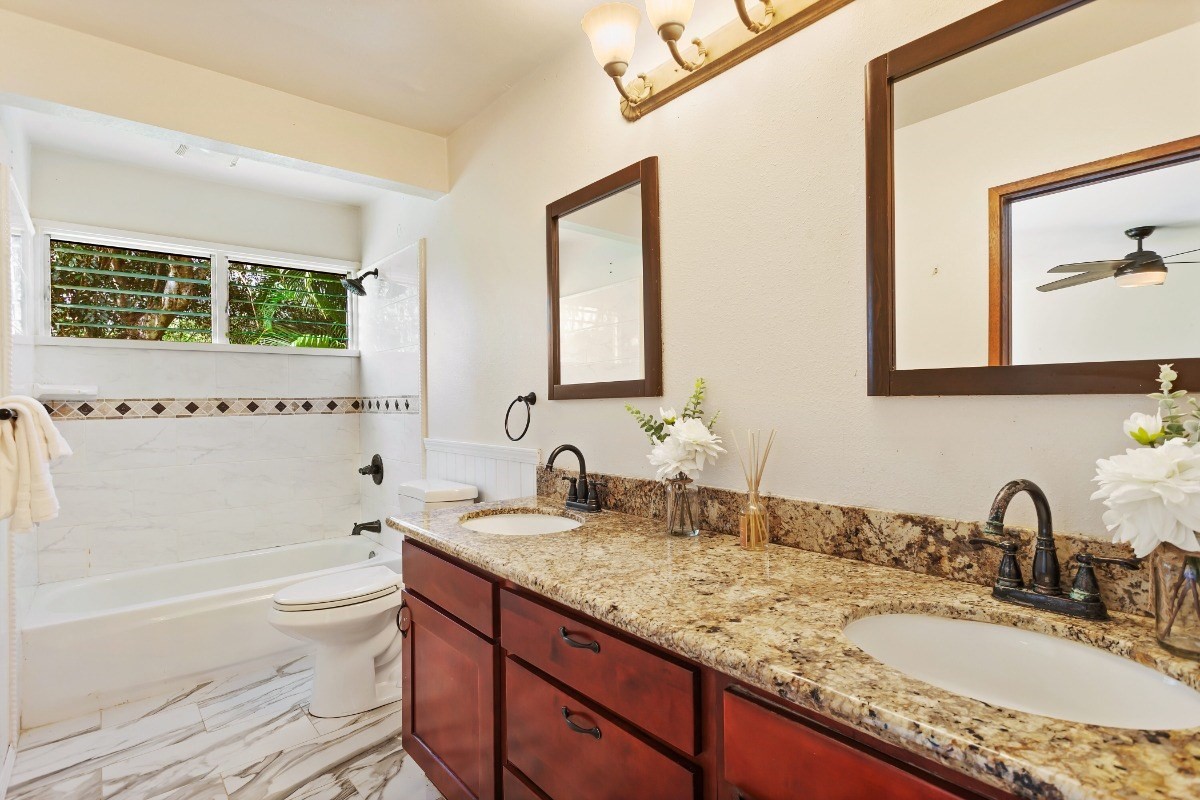 4701 Kawaihau Road, Unit L102 Kapaa, HI 96746 - Photo 13 of 22 a bathroom with a granite countertop sink a toilet and bathtub