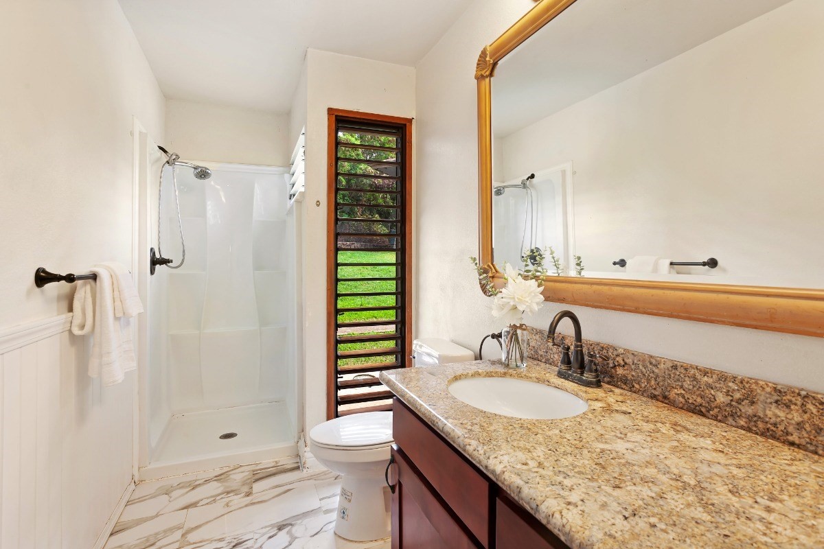 4701 Kawaihau Road, Unit L102 Kapaa, HI 96746 - Photo 17 of 22 a bathroom with a granite countertop sink a toilet and shower