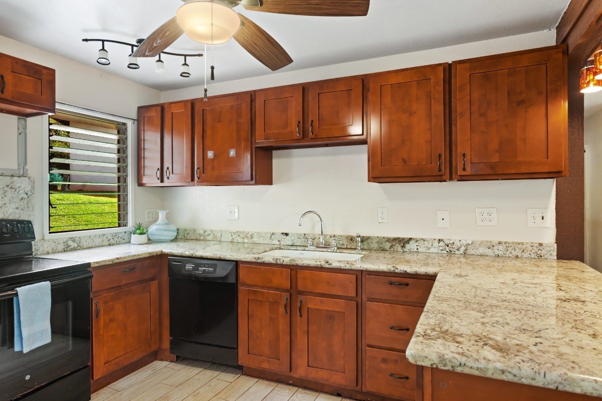 4701 Kawaihau Road, Unit L102 Kapaa, HI 96746 - Photo 7 of 22 a kitchen with stainless steel appliances granite countertop wooden cabinets a sink and dishwasher