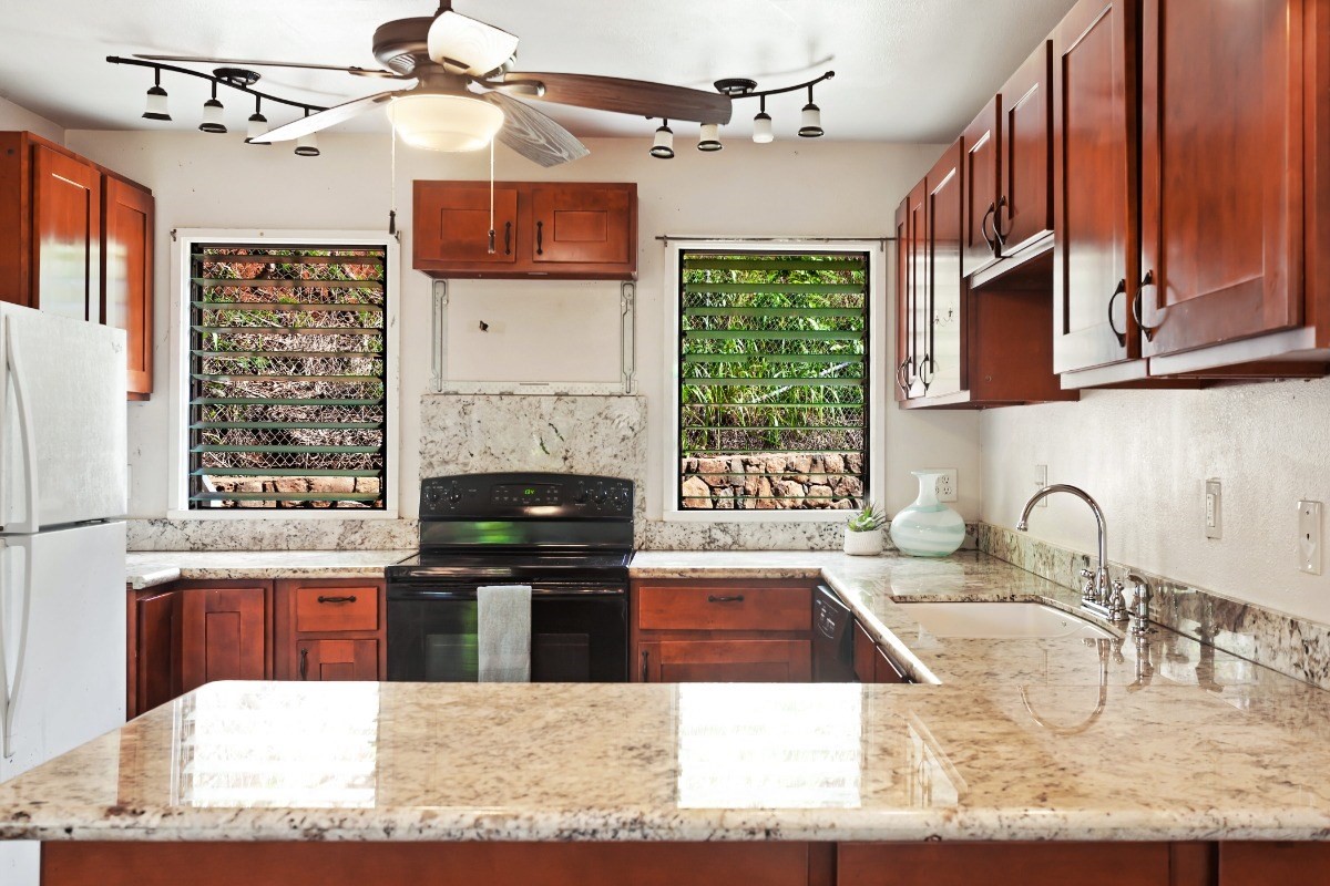 4701 Kawaihau Road, Unit L102 Kapaa, HI 96746 - Photo 8 of 22 a kitchen with granite countertop a stove a sink and a microwave