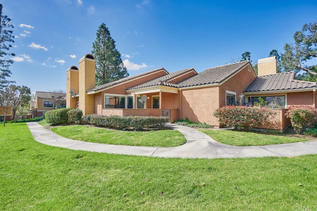 10655 Lemon Avenue, Unit 102 Rancho Cucamonga, CA 91737 - Photo 1 of 1 a front view of a house with a garden