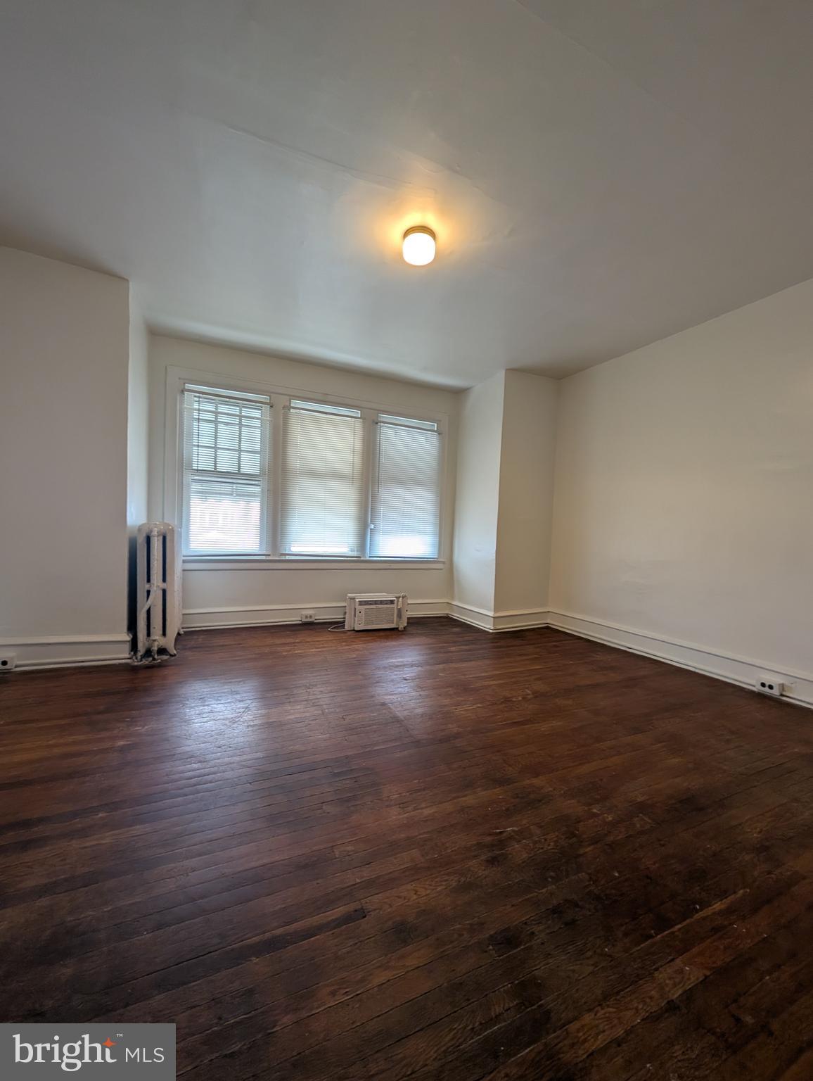 5927 Springfield Avenue Philadelphia, PA 19143 - Photo 12 of 17 an empty room with wooden floor and windows