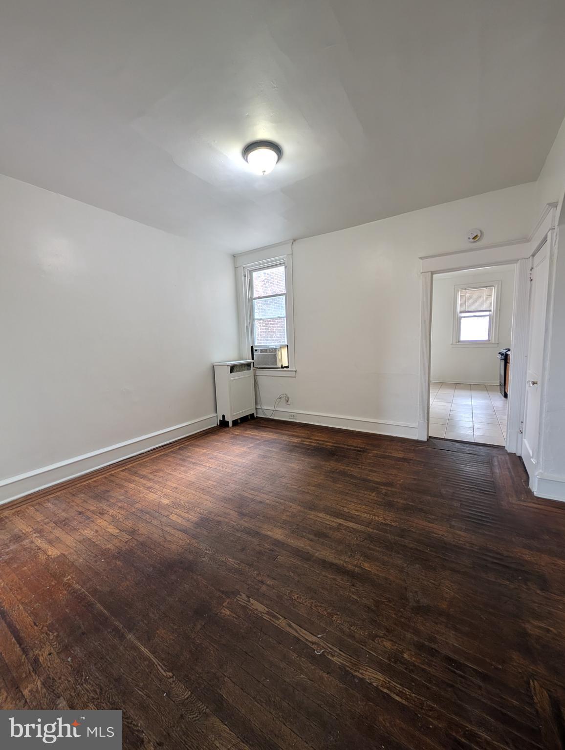 5927 Springfield Avenue Philadelphia, PA 19143 - Photo 3 of 17 an empty room with wooden floor and windows