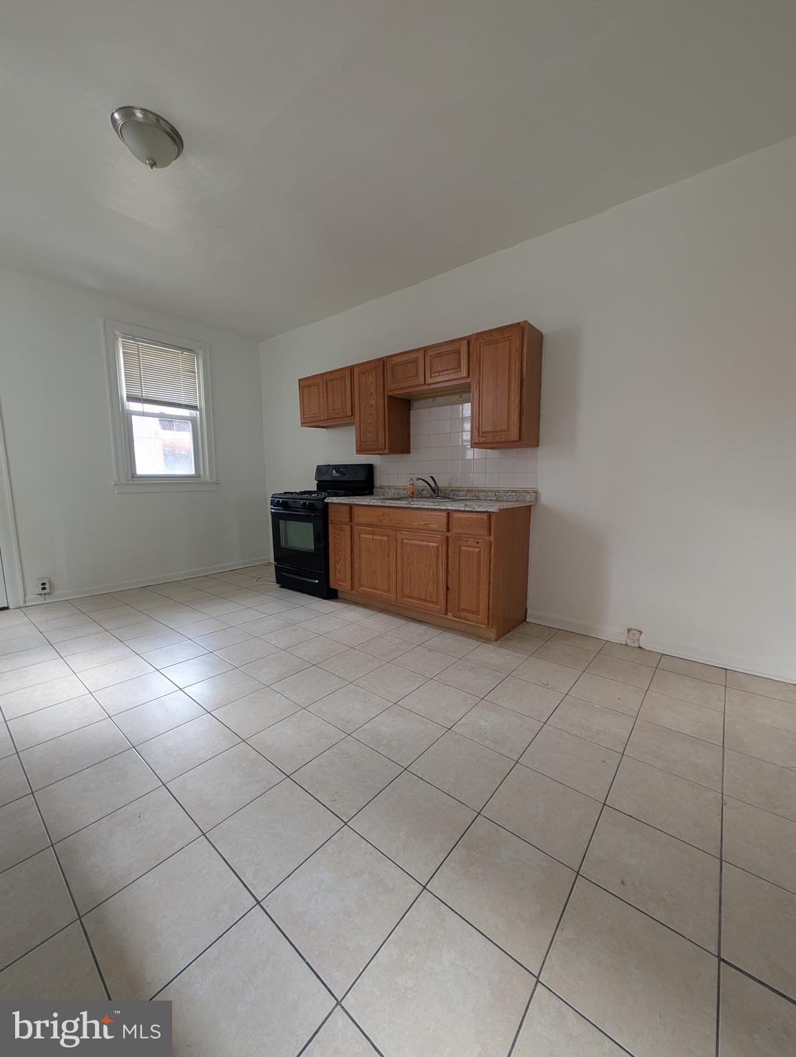 5927 Springfield Avenue Philadelphia, PA 19143 - Photo 5 of 17 a kitchen with granite countertop a sink a stove top oven and cabinets